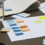 An educator works out the details on her concept map using pen, paper, and sticky-notes