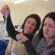 Susie, Ivona, and David measure the water temperature in test tube 'oceans' at the Ice Cube Investigation Station